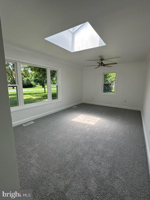 8357 Gannon Cir, Easton, MD 21601 - empty room featuring a skylight, carpet floors, a ceiling fan, and crown molding