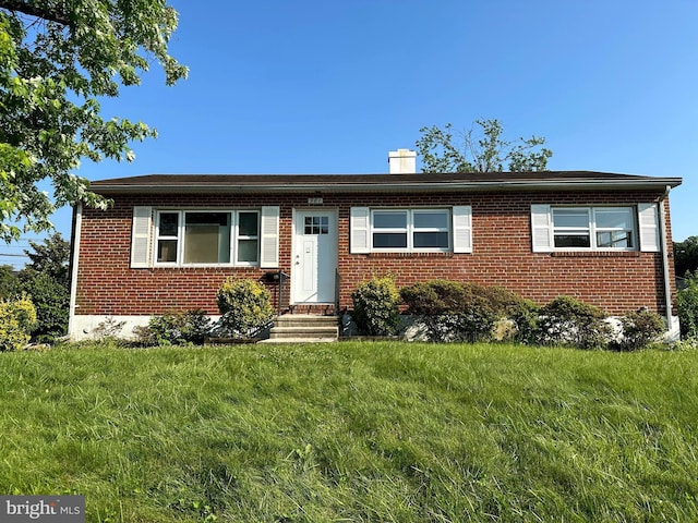 901 Vanderwood Rd, Baltimore, MD 21228 - view of front facade featuring brick siding, a chimney, a front yard, and entry steps