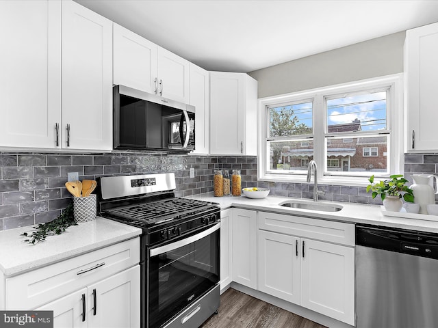 901 Vanderwood Rd, Baltimore, MD 21228 - kitchen with appliances with stainless steel finishes, white cabinetry, decorative backsplash, and wood finished floors