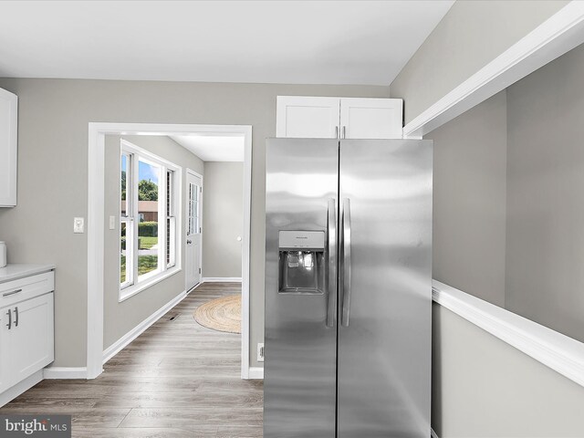 901 Vanderwood Rd, Baltimore, MD 21228 - kitchen with stainless steel fridge, light wood-style flooring, white cabinets, and light countertops