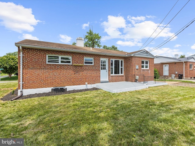 901 Vanderwood Rd, Baltimore, MD 21228 - rear view of property with brick siding, a patio, a chimney, and a lawn