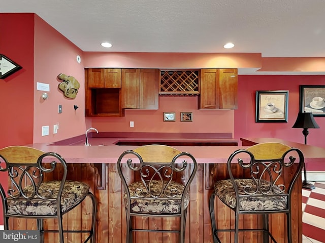 3067 Shingle Camp Rd, Mc Henry, MD 21541 - kitchen with a breakfast bar, brown cabinetry, a peninsula, and recessed lighting