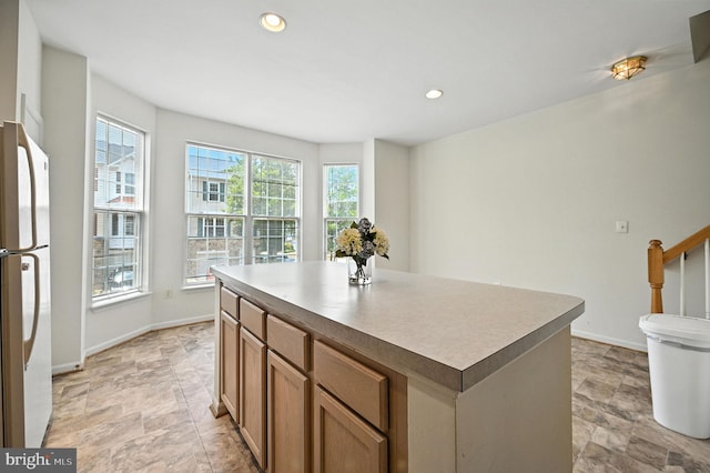 6949 Banchory Ct, Alexandria, VA 22315 - kitchen featuring stone finish flooring, freestanding refrigerator, a kitchen island, recessed lighting, and brown cabinets