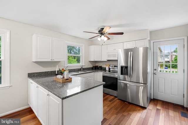 5315 Debbie Ct, Ellicott City, MD 21043 - kitchen featuring appliances with stainless steel finishes, a peninsula, white cabinetry, and dark stone countertops