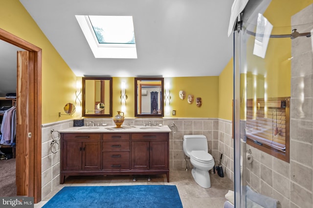 16 Golfview Ln, Reading, PA 19606 - bathroom featuring tile walls, a wainscoted wall, a skylight, double vanity, and tile patterned flooring
