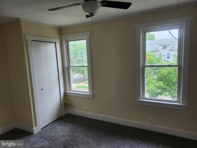 301 Heulings Ave, Riverside, NJ 08075 - unfurnished bedroom with multiple windows, dark carpet, ornamental molding, and ceiling fan
