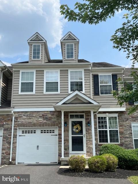 4549 Woodbrush Way, Allentown, PA 18104 - view of property featuring stone siding, an attached garage, and asphalt driveway