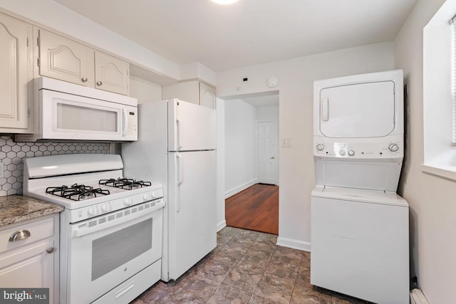 1615 S 16th St, Philadelphia, PA 19145 - kitchen featuring white appliances, estacked washer and dryer, backsplash, light countertops, and stone finish floors