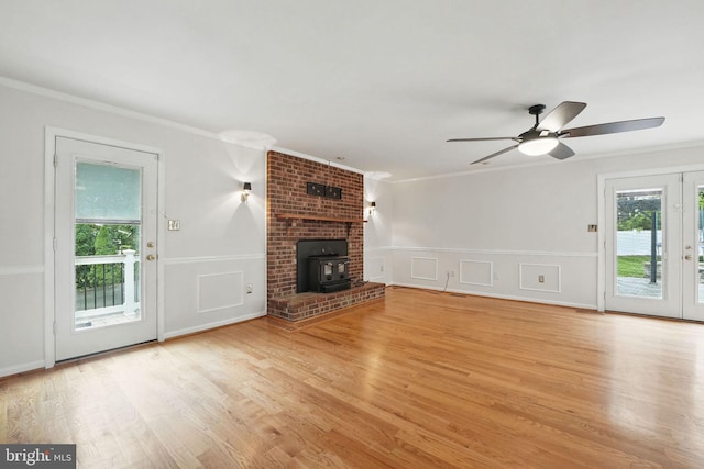 4009 Gypsum Hill Rd, Haymarket, VA 20169 - unfurnished living room with ornamental molding, a wood stove, a ceiling fan, light wood-style flooring, and a decorative wall