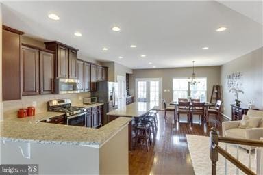 45952 Iron Oak Ter, Sterling, VA 20166 - kitchen with appliances with stainless steel finishes, recessed lighting, dark wood-style flooring, a center island, and a breakfast bar