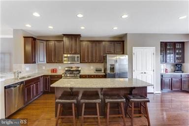 45952 Iron Oak Ter, Sterling, VA 20166 - kitchen with appliances with stainless steel finishes, light stone counters, a center island, recessed lighting, and wood finished floors