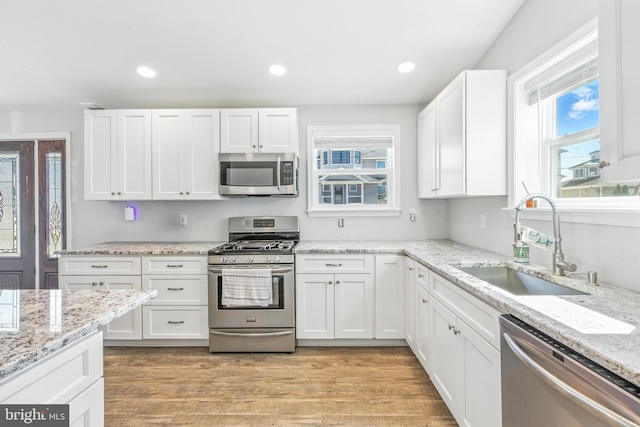 83 Morton Dr, Manahawkin, NJ 08050 - kitchen with appliances with stainless steel finishes, white cabinetry, recessed lighting, light stone countertops, and light wood-type flooring