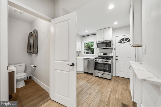 2230 Watkins St, Philadelphia, PA 19145 - kitchen featuring stainless steel appliances, light wood-style flooring, white cabinetry, light stone countertops, and recessed lighting