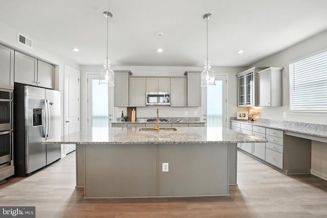 18286 Summit Pointe Dr, Triangle, VA 22172 - kitchen with appliances with stainless steel finishes, gray cabinets, light stone counters, light wood finished floors, and recessed lighting