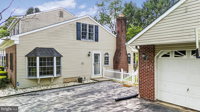 1559 Washington Ln, West Chester, PA 19382 - back of property with brick siding, a chimney, and a garage