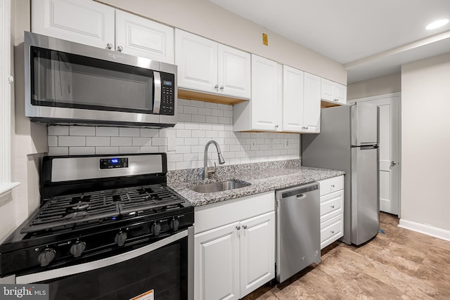 838 Benninghaus Rd, Baltimore, MD 21212 - kitchen featuring appliances with stainless steel finishes, backsplash, white cabinetry, and light stone countertops