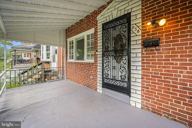 838 Benninghaus Rd, Baltimore, MD 21212 - view of exterior entry with brick siding, a porch, and a carport