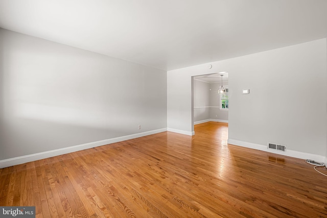 838 Benninghaus Rd, Baltimore, MD 21212 - unfurnished room with light wood-style floors and a chandelier