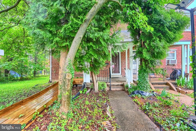3702 Kingwood Sq, Baltimore, MD 21215 - view of front facade featuring brick siding, cooling unit, and a porch