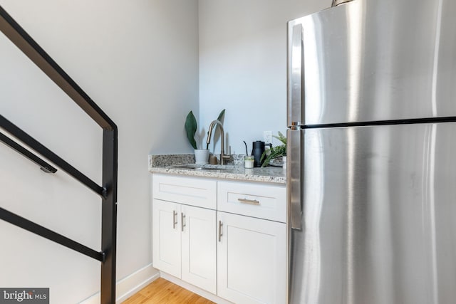 1229 S Bucknell St, Philadelphia, PA 19146 - bar with freestanding refrigerator, light wood finished floors, and stairs