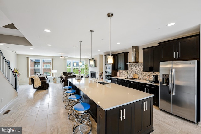22416 Philanthropic Dr, Ashburn, VA 20148 - kitchen featuring stainless steel appliances, wall chimney range hood, open floor plan, tasteful backsplash, and light countertops