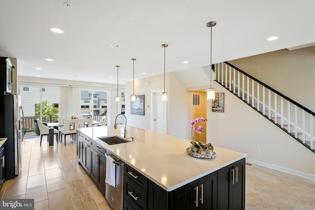 22416 Philanthropic Dr, Ashburn, VA 20148 - kitchen featuring dark cabinetry, stainless steel appliances, a large island with sink, light countertops, and decorative light fixtures
