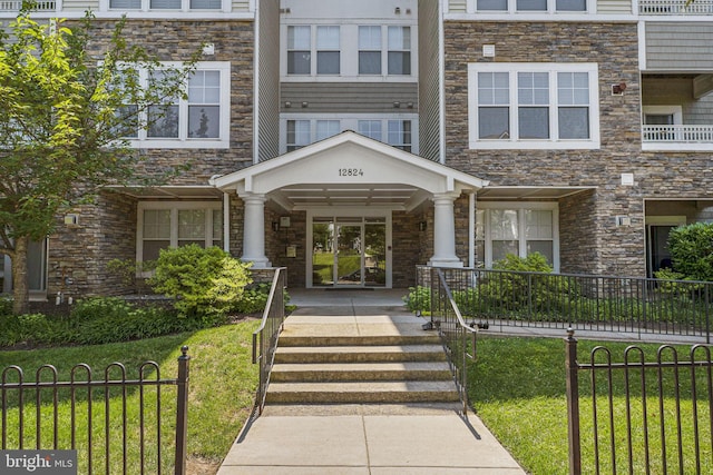 12824 Clarksburg Square Rd Unit 406, Clarksburg, MD 20871 - property entrance with stone siding, a porch, and a lawn