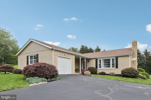 611 Hillcrest Dr, Perkasie, PA 18944 - ranch-style home with a chimney, a garage, driveway, brick siding, and a front lawn