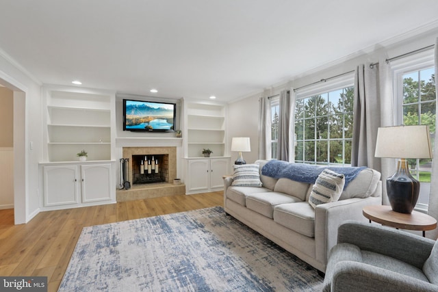 611 Hillcrest Dr, Perkasie, PA 18944 - living area featuring light wood-style floors, a fireplace with raised hearth, crown molding, built in features, and recessed lighting