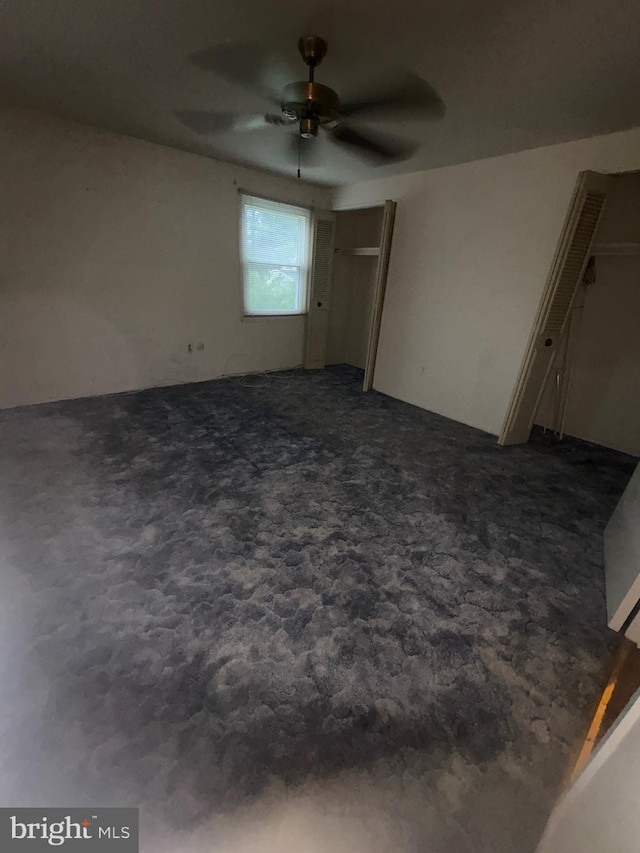 2713 Federal Ln, Bowie, MD 20715 - unfurnished bedroom with dark colored carpet, multiple closets, and ceiling fan