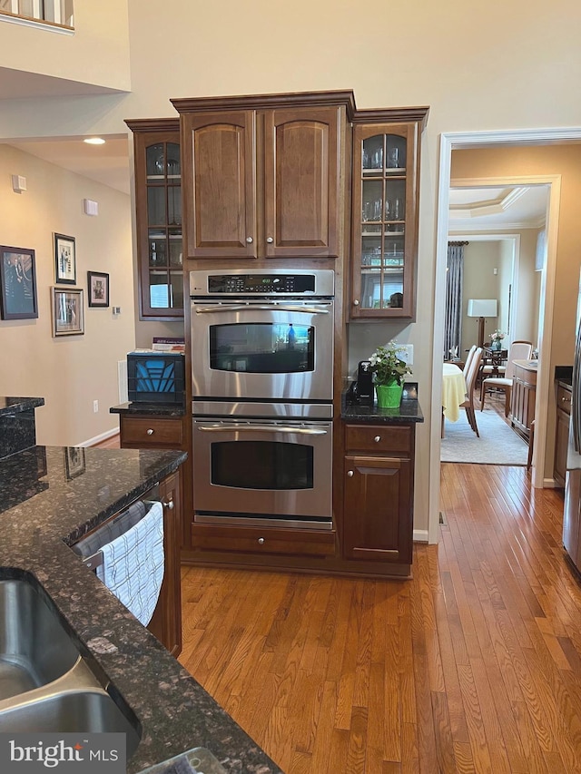 10600 Edwardian Ln, New Market, MD 21774 - kitchen with appliances with stainless steel finishes, hardwood / wood-style flooring, dark stone counters, and glass insert cabinets