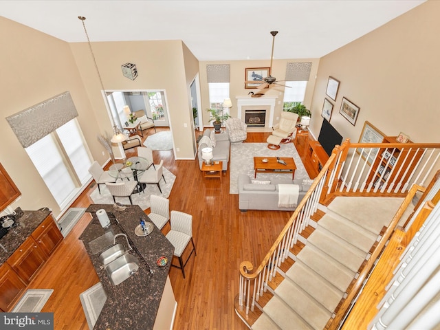 10600 Edwardian Ln, New Market, MD 21774 - living area featuring wood finished floors, a ceiling fan, a fireplace, stairs, and high vaulted ceiling