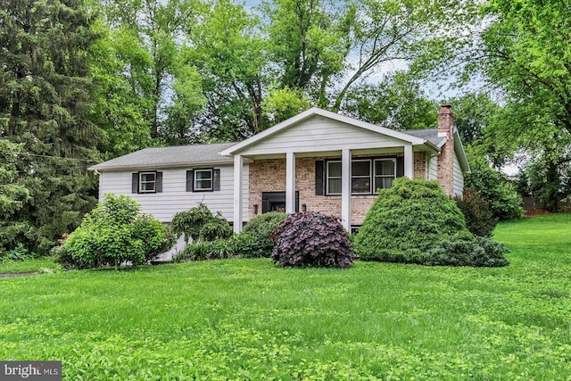301 N Lynbrook Dr N, York, PA 17402 - view of front of home featuring a front yard, a chimney, and brick siding