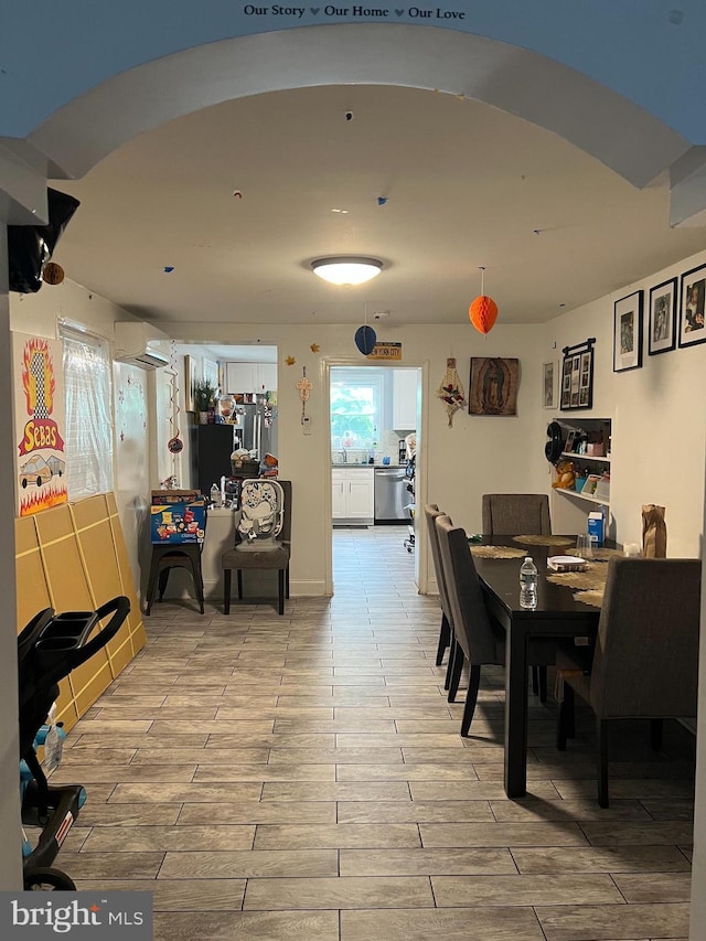 2612 E Somerset St, Philadelphia, PA 19134 - dining space featuring an AC wall unit, wood finish floors, and arched walkways