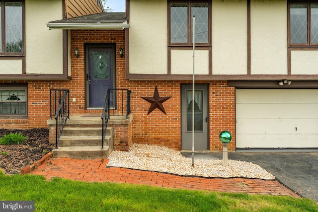 1721 Pioneer Rd, Lancaster, PA 17602 - view of exterior entry with stucco siding, brick siding, an attached garage, and asphalt driveway