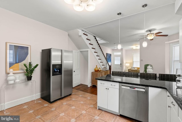 745 Gresham Pl NW, Washington, DC 20001 - kitchen with appliances with stainless steel finishes, white cabinets, dark stone countertops, ceiling fan, and hanging light fixtures