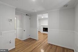 3241 N St NW Unit 1, Washington, DC 20007 - spare room with wood finished floors, ornamental molding, and a fireplace
