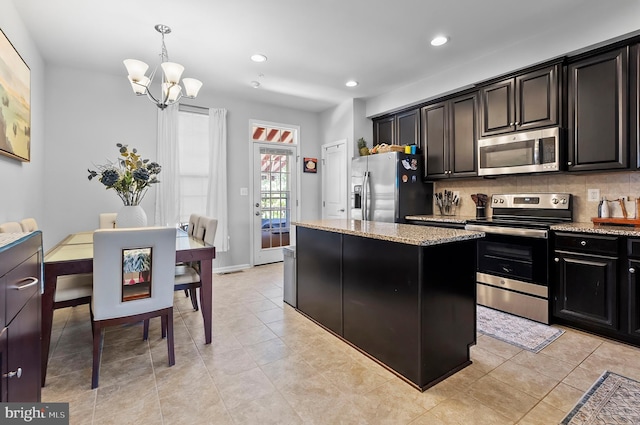 922 S Macon St, Baltimore, MD 21224 - kitchen with appliances with stainless steel finishes, a kitchen island, a chandelier, light stone counters, and recessed lighting