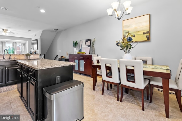 922 S Macon St, Baltimore, MD 21224 - kitchen with dark cabinetry, a center island, a chandelier, light stone counters, and ceiling fan