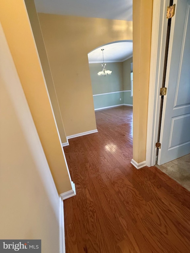 169 Millington Rd, Millington, MD 21651 - hallway featuring dark wood finished floors, arched walkways, a chandelier, and ornamental molding