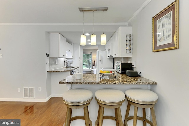 1581 Poplar Grove Dr, Reston, VA 20194 - kitchen with wood finished floors, tasteful backsplash, white cabinetry, white appliances, and ornamental molding