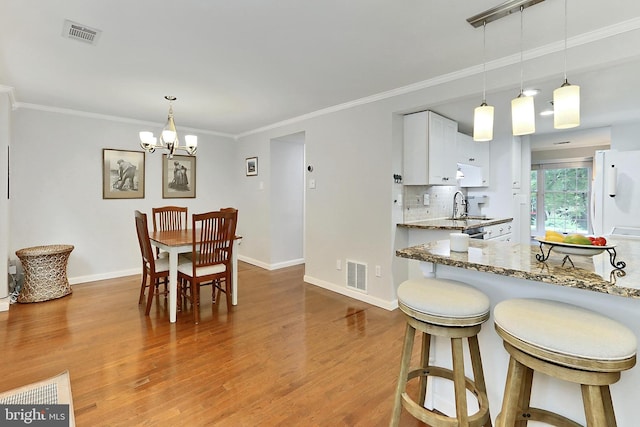 1581 Poplar Grove Dr, Reston, VA 20194 - dining area featuring light wood-type flooring, a chandelier, and ornamental molding