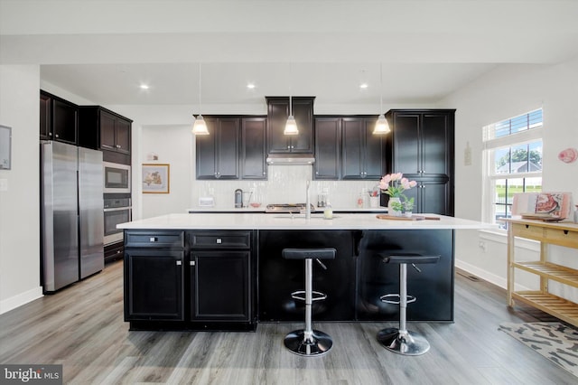 33 Winifred, Hanover, PA 17331 - kitchen featuring stainless steel appliances, a spacious island, decorative backsplash, light countertops, and light wood-type flooring