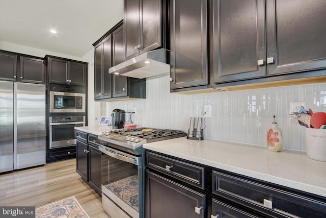 33 Winifred, Hanover, PA 17331 - kitchen with appliances with stainless steel finishes, under cabinet range hood, decorative backsplash, and light wood-style floors