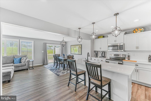 300 Hayward Ct, Pottstown, PA 19464 - kitchen featuring appliances with stainless steel finishes, light countertops, a kitchen bar, light wood finished floors, and recessed lighting