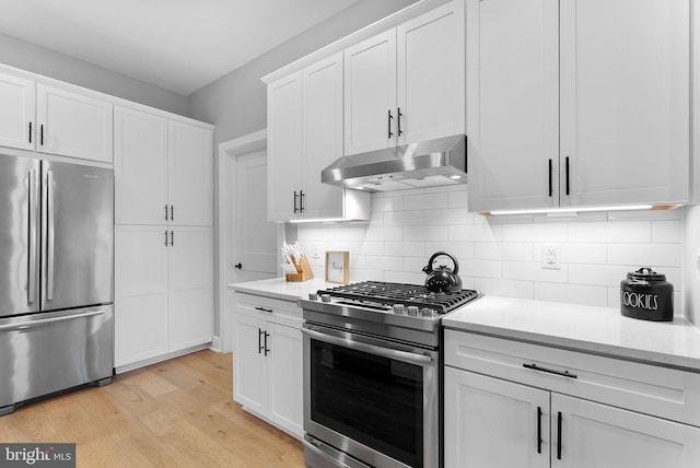 44691 Wellfleet Dr Unit 306, Ashburn, VA 20147 - kitchen featuring appliances with stainless steel finishes, exhaust hood, white cabinets, and decorative backsplash