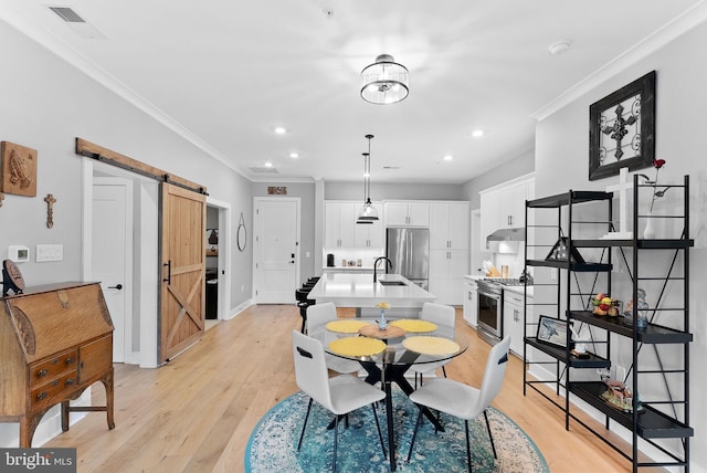 44691 Wellfleet Dr Unit 306, Ashburn, VA 20147 - dining room featuring a barn door, light wood finished floors, crown molding, and recessed lighting