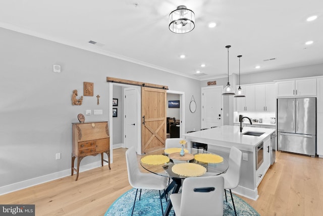 44691 Wellfleet Dr Unit 306, Ashburn, VA 20147 - dining room with a barn door, crown molding, recessed lighting, and light wood-style floors