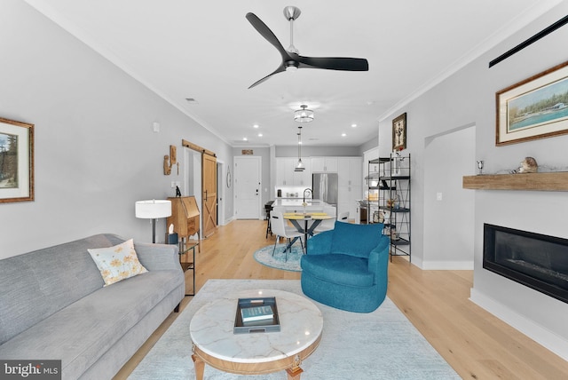 44691 Wellfleet Dr Unit 306, Ashburn, VA 20147 - living area featuring light wood-style flooring, a ceiling fan, crown molding, a glass covered fireplace, and recessed lighting