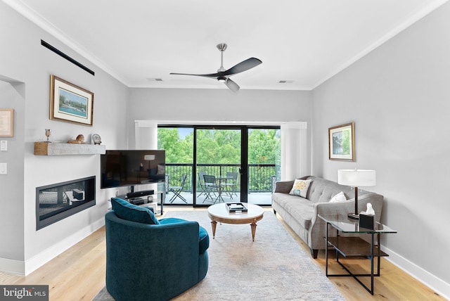44691 Wellfleet Dr Unit 306, Ashburn, VA 20147 - living area featuring ceiling fan, crown molding, wood finished floors, and a glass covered fireplace